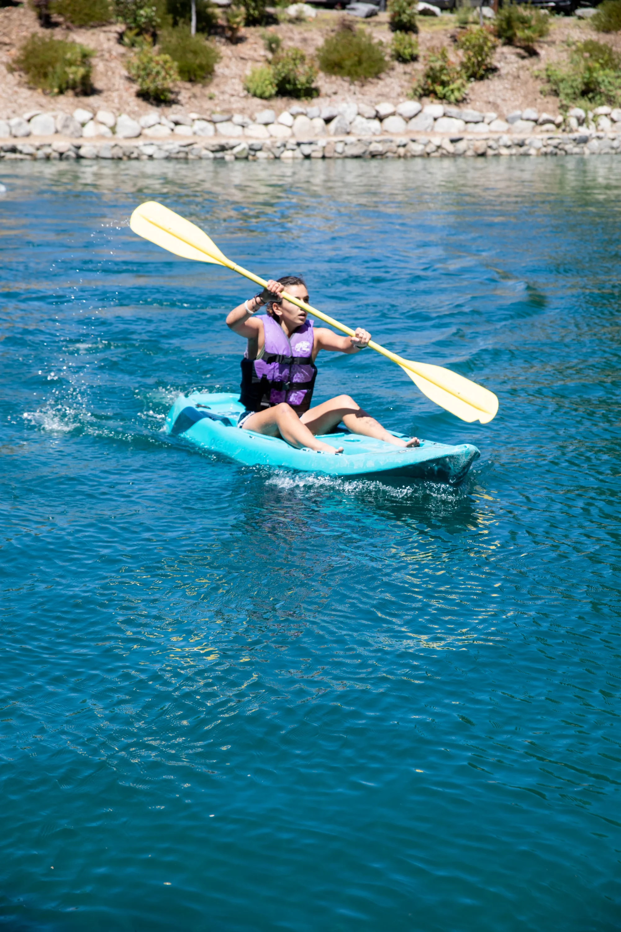 activities girl purple vest kayaking blue kayak