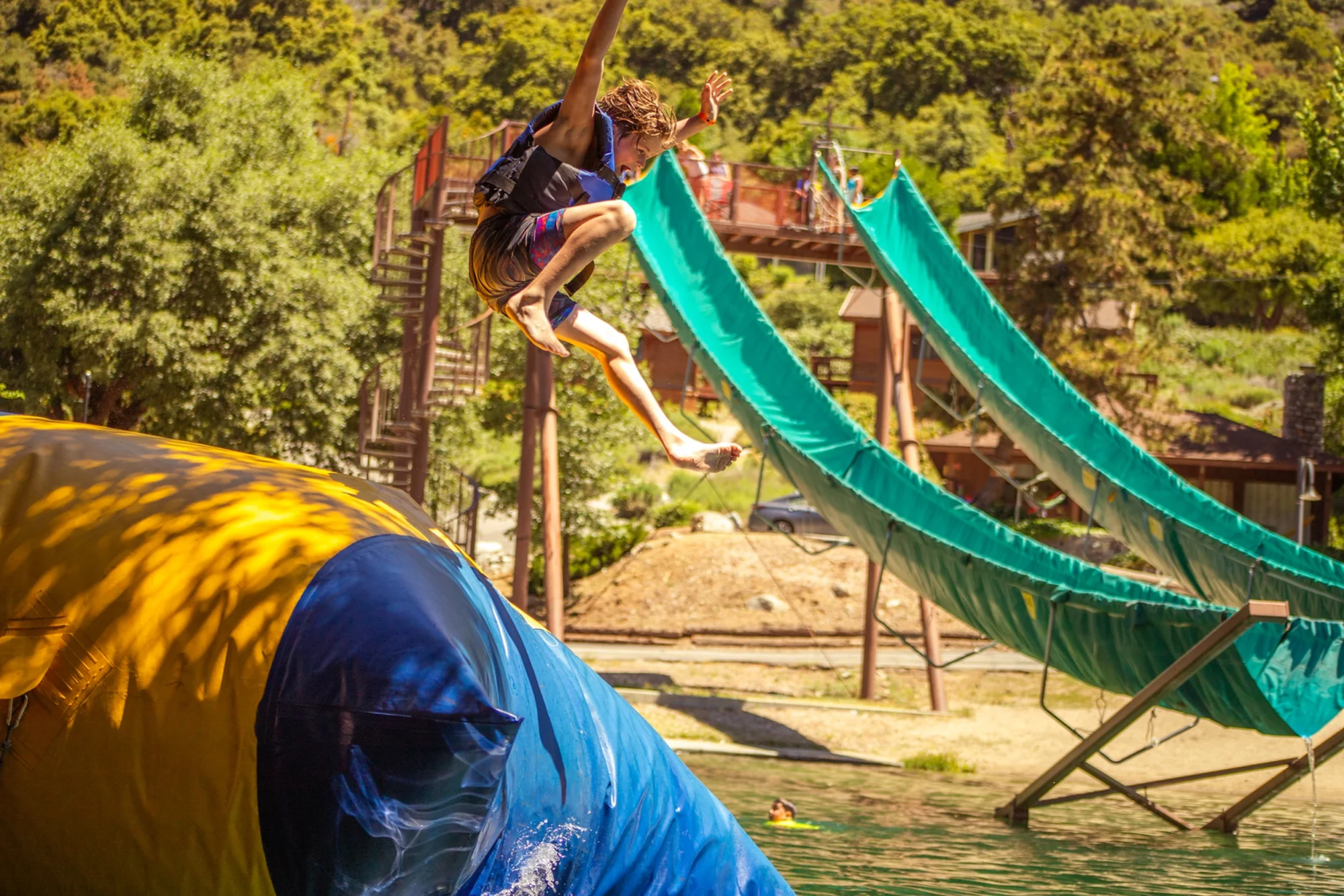 family camp blob boy flying mid air water slide
