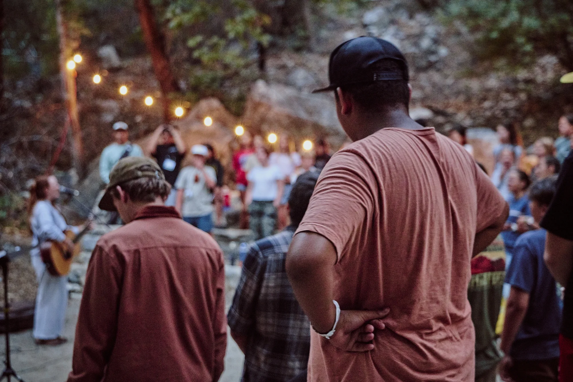 family camp evening outdoor worship crowd string lights trees
