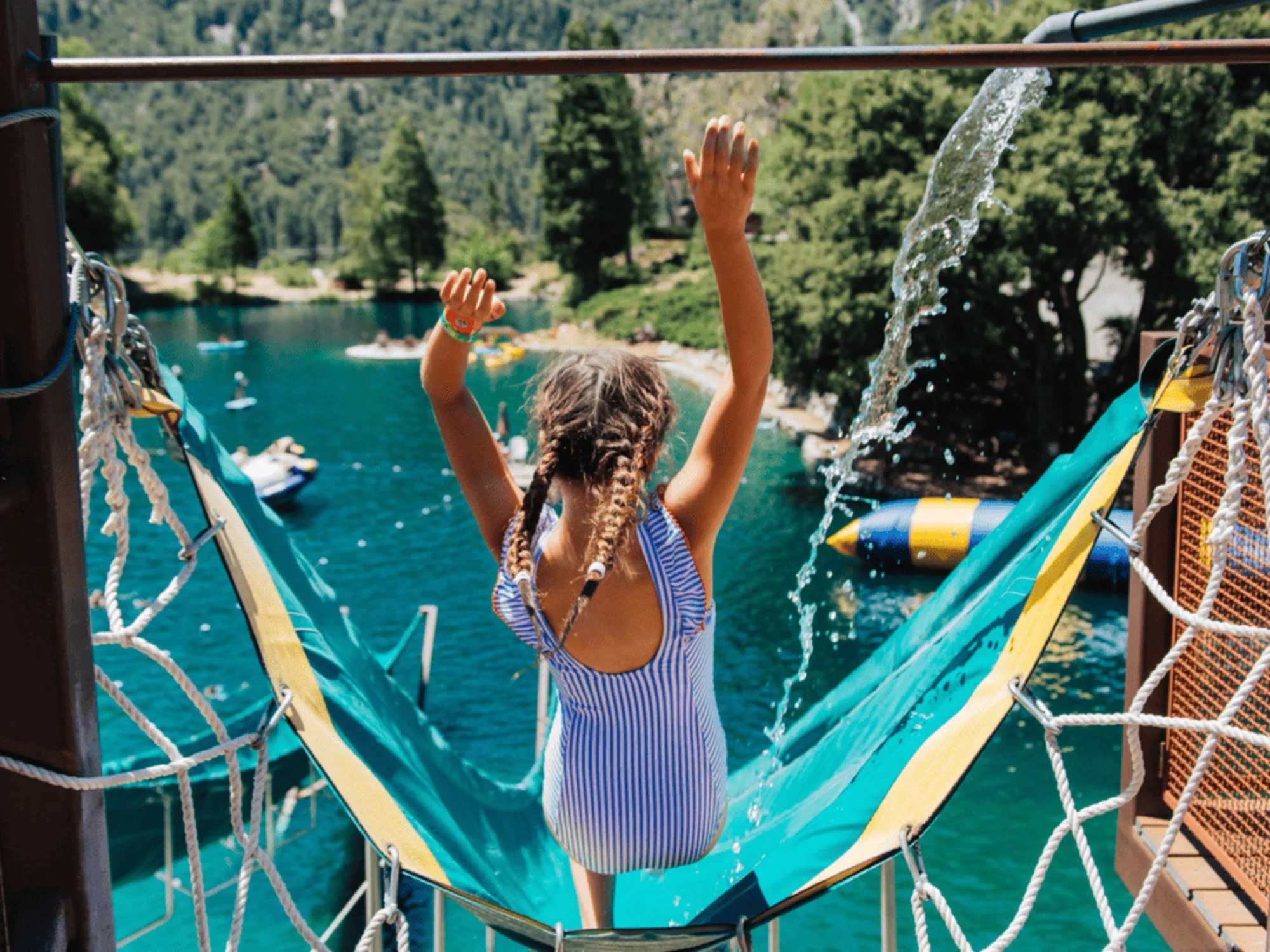 family camp giant water slide girl overlooking turquoise lake