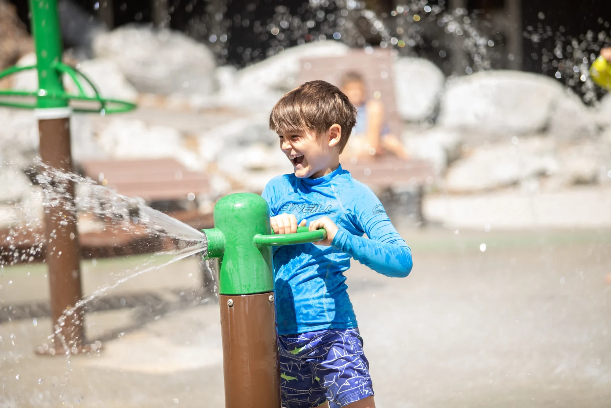 family camp splash pad boy laughing water cannon fun