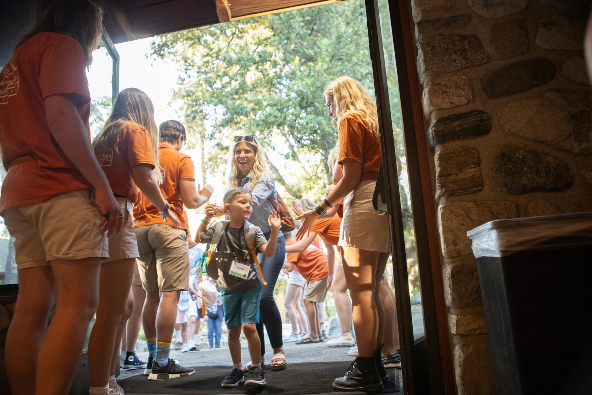 family camp staff welcoming boy excited arrival entrance