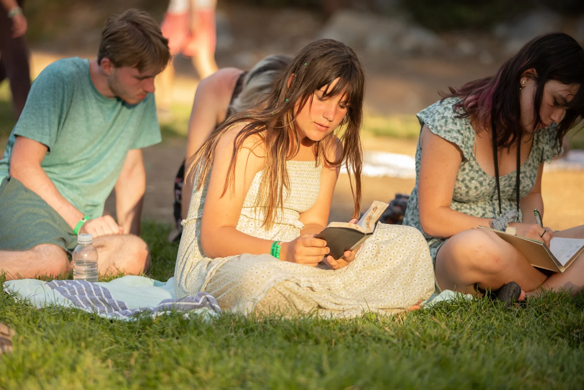 family camp young adults reading bibles grass bible study