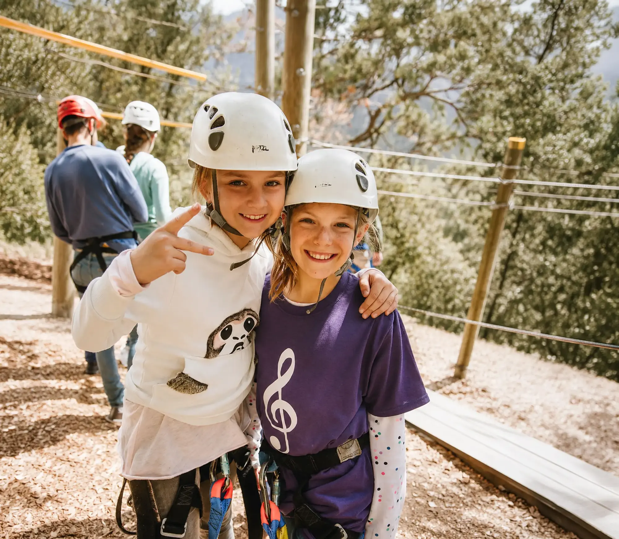 family camp zipline two kids helmets smiling portrait e2