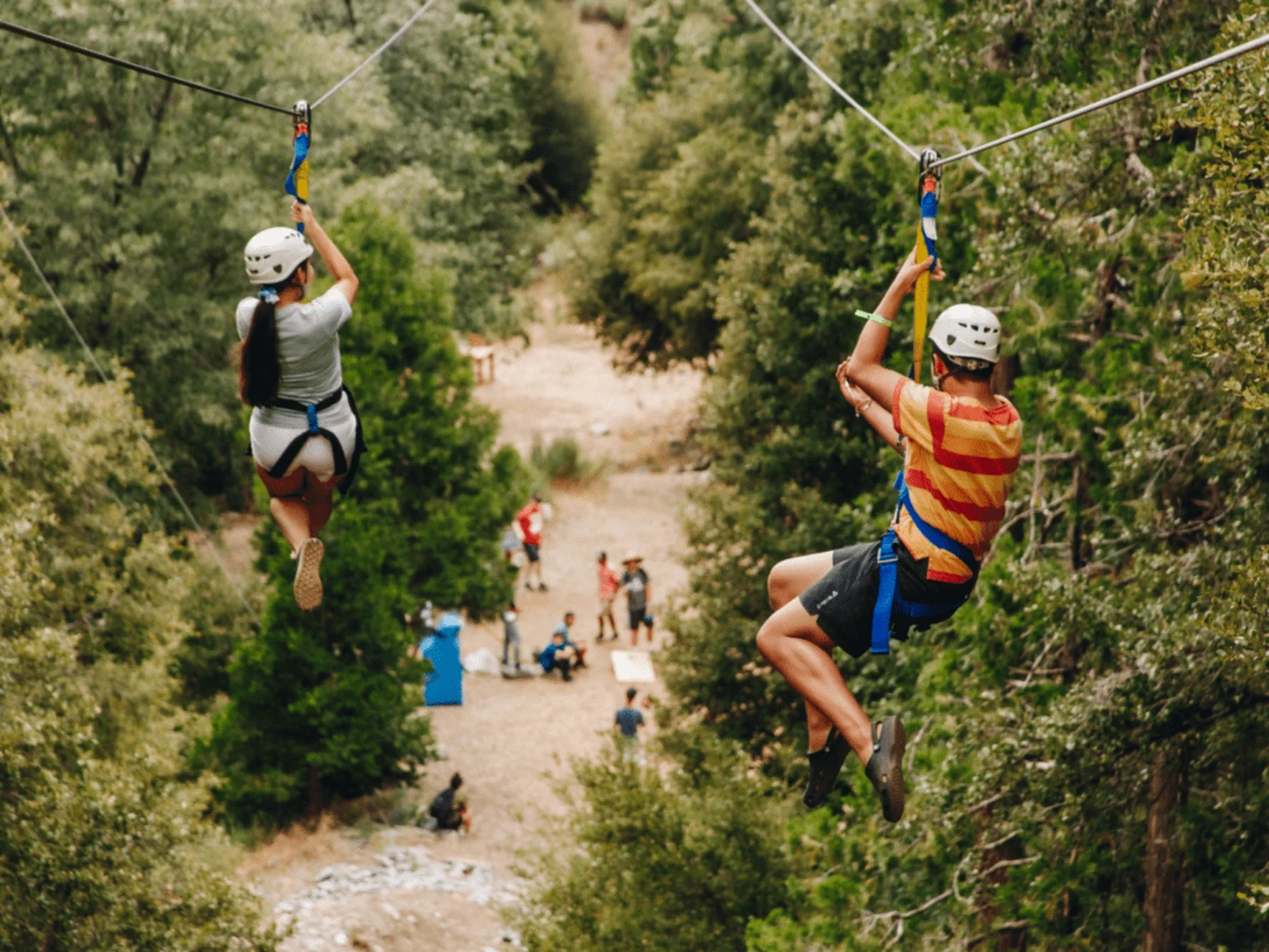 family camp zipline two riders side by side aerial