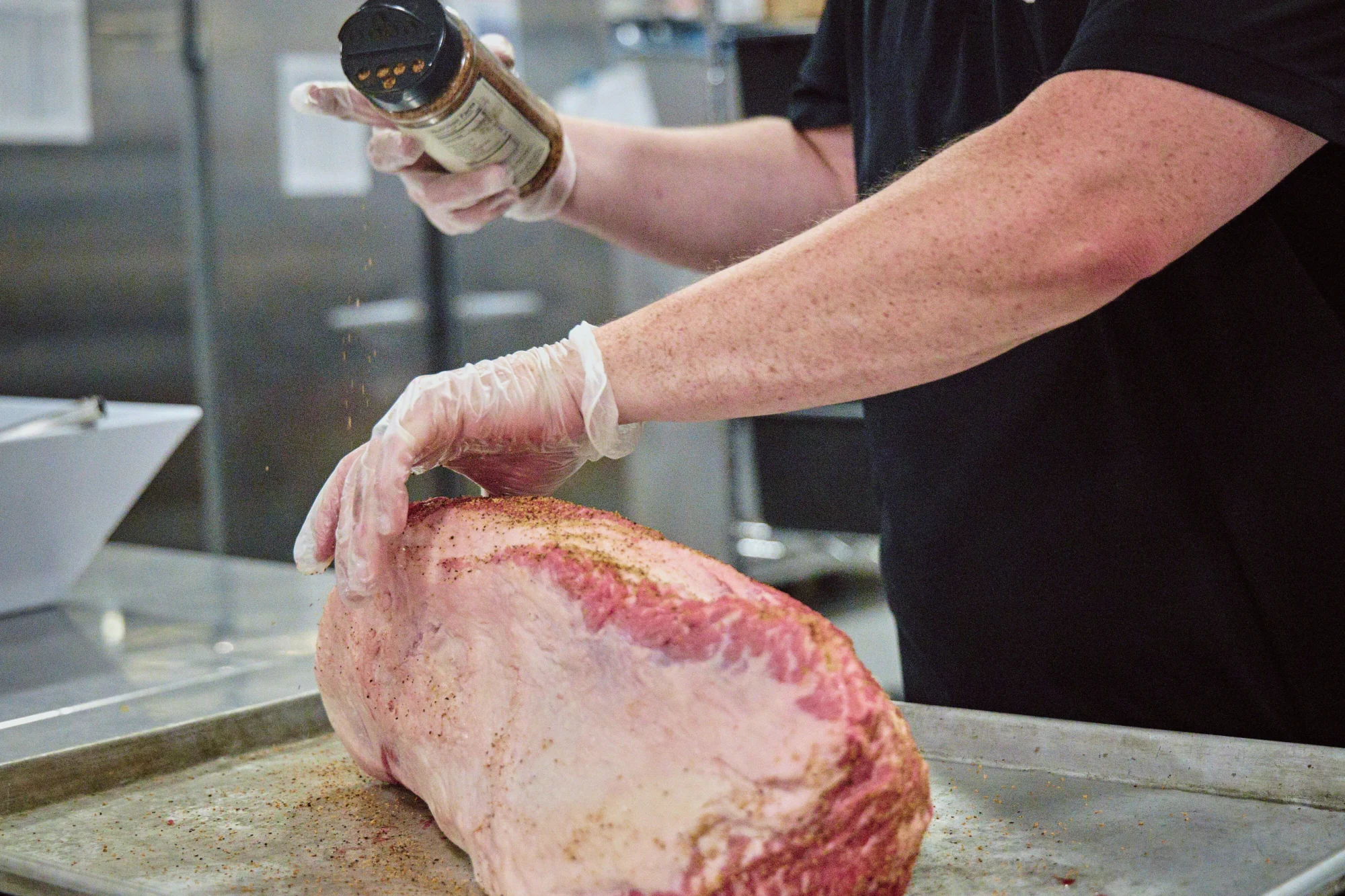 food dining chef applying spice rub on beef roast closeup