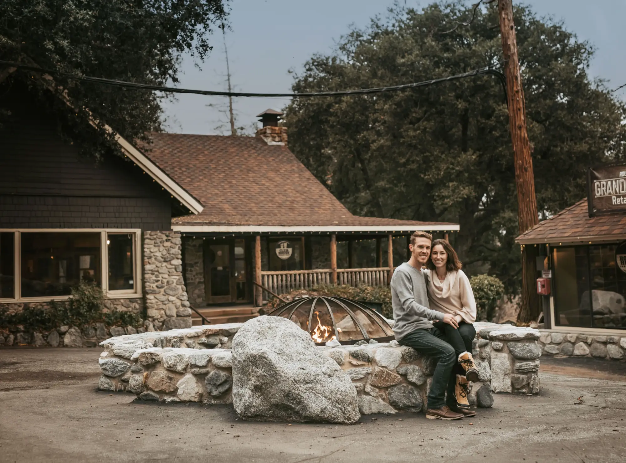 guest retreats couple sitting stone firepit lodge e1