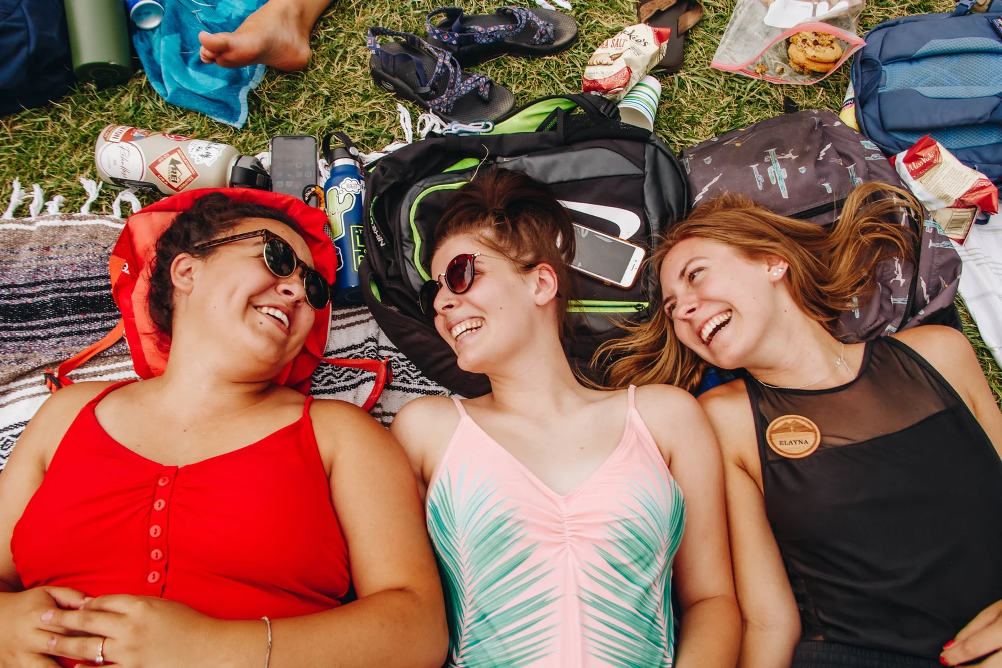 radiant three staff friends laughing lying grass summer relaxation