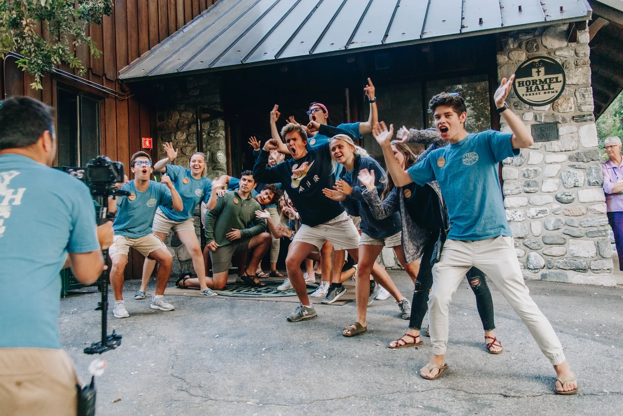 staff fun action poses outside hormel hall stone building