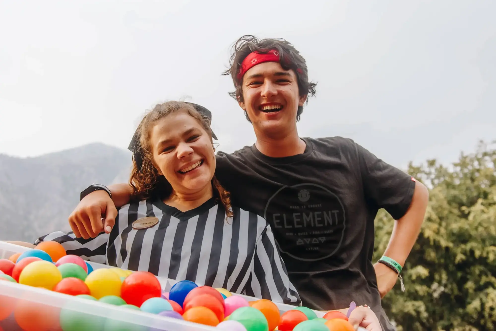 two staff members smiling colorful ball pit mountains e1