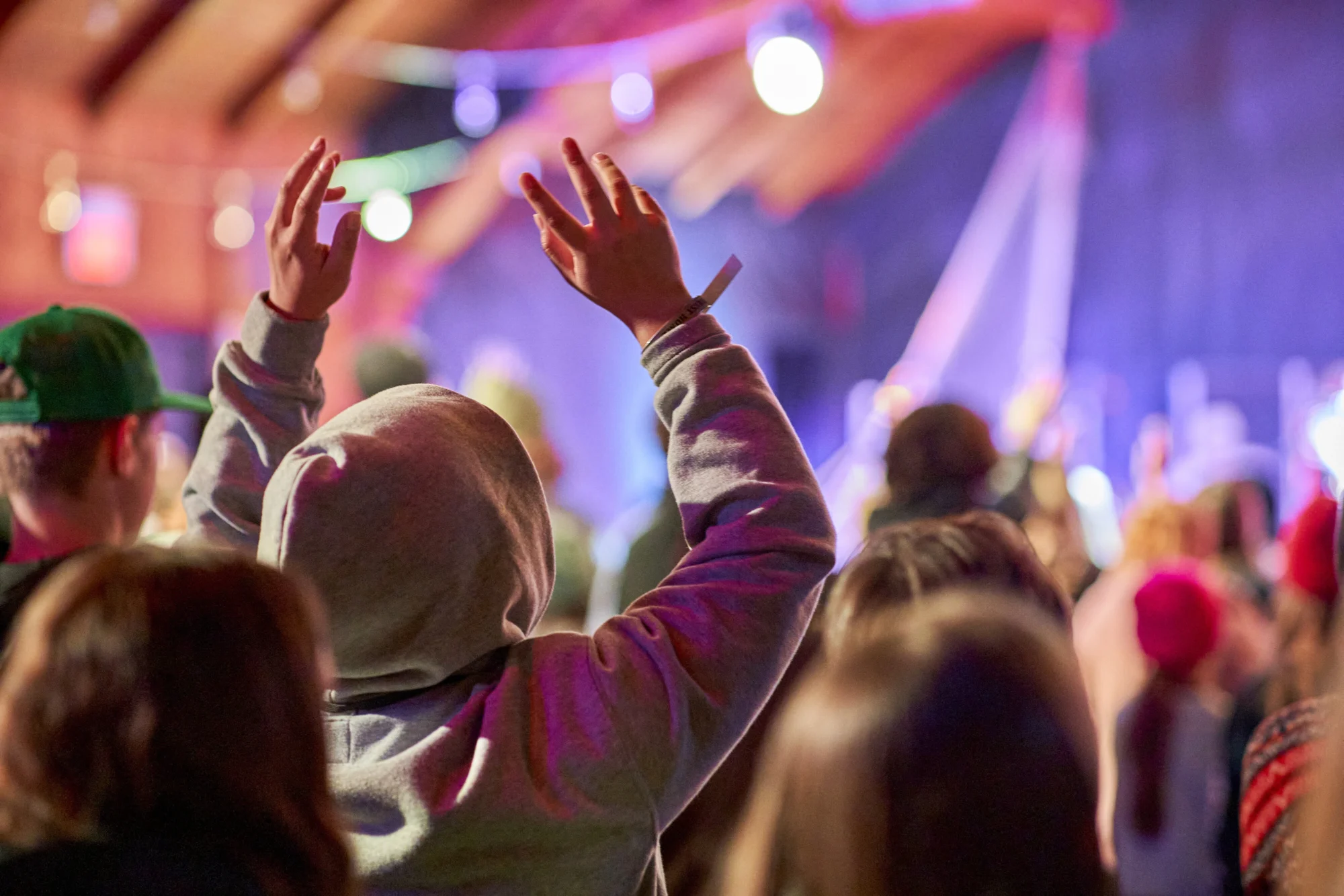 winter camp youth youth hands raised worship colorful stage lights