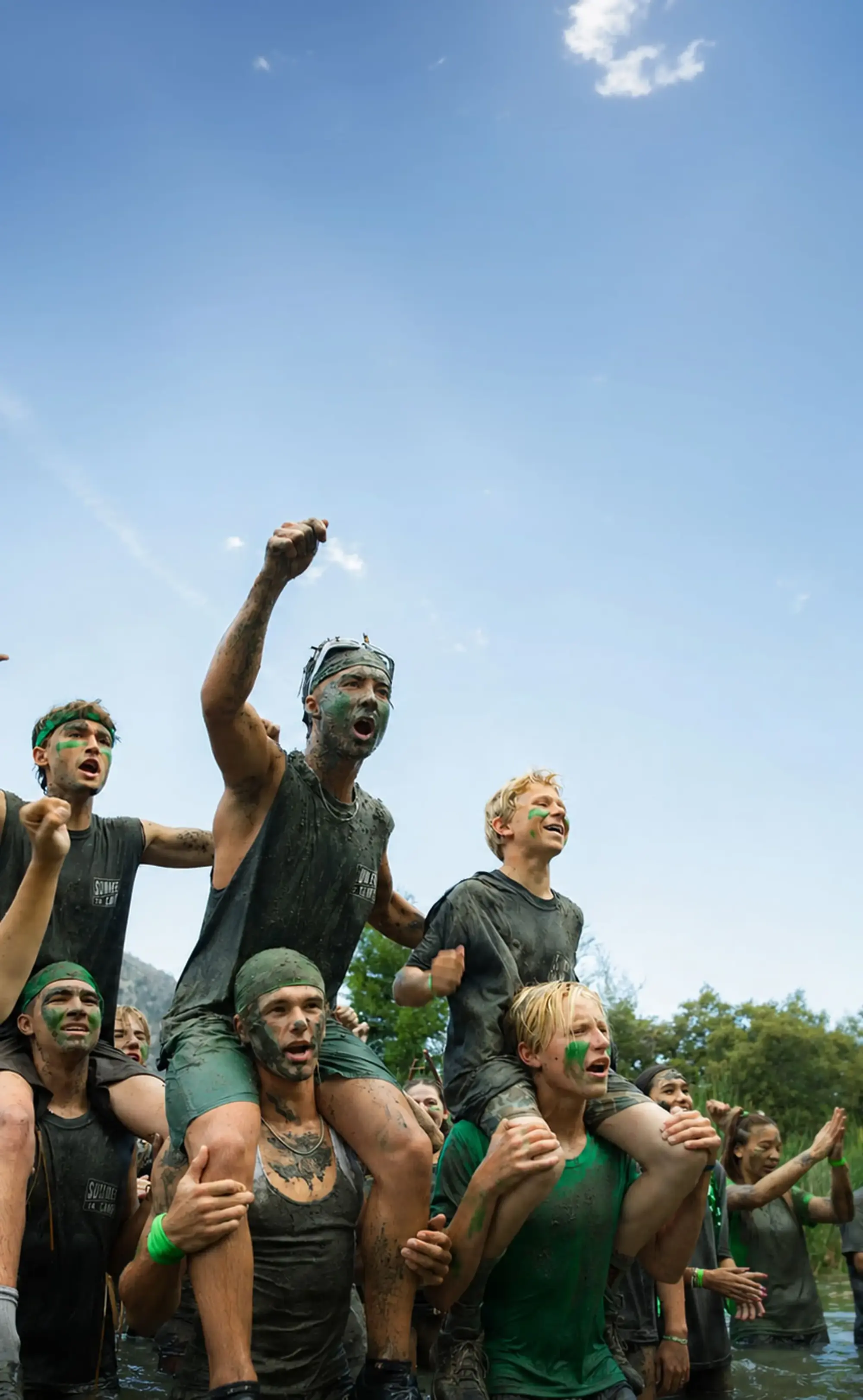 youth campers green team victory celebration mud covered tall e1