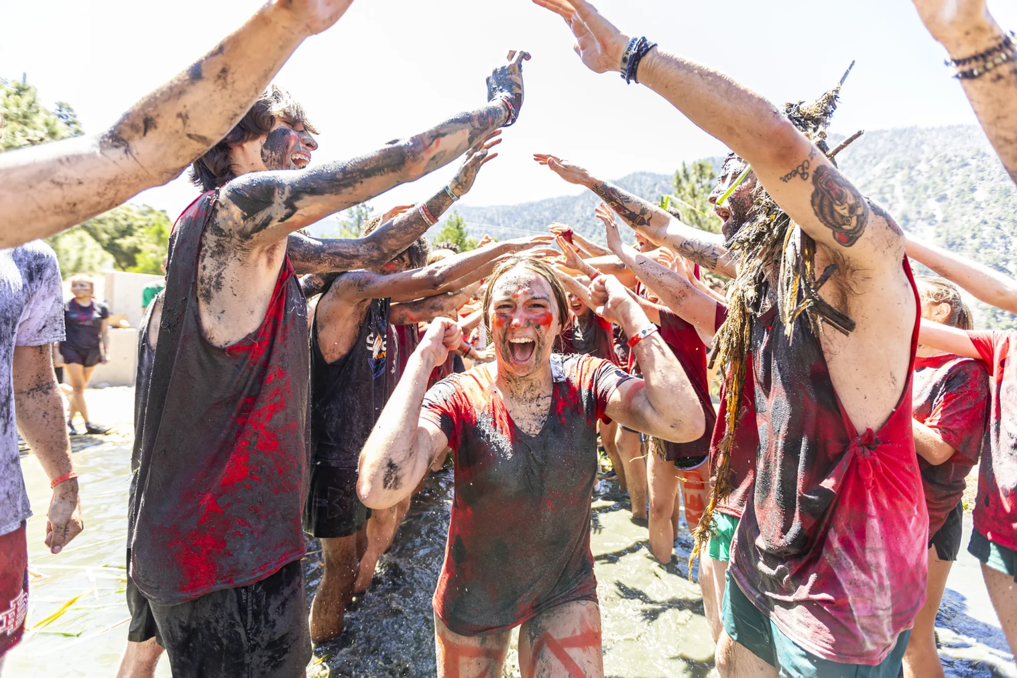 youth campers red team mud bowl celebration arms raised